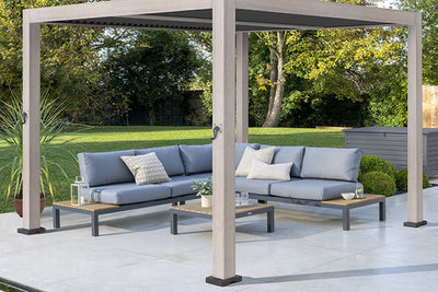 Modern outdoor sofa seating under a pergola in a landscaped backyard.