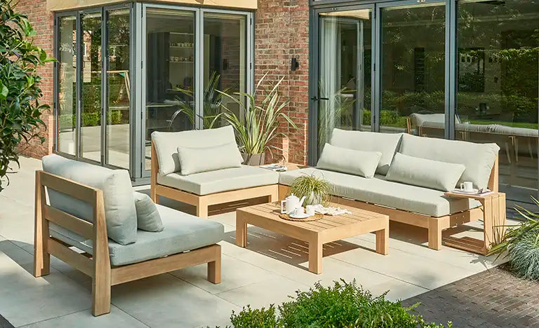 Wooden outdoor seating set with cushioned sofas on a modern patio.