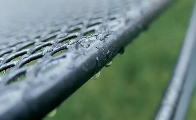 Raindrops on a metal mesh outdoor surface