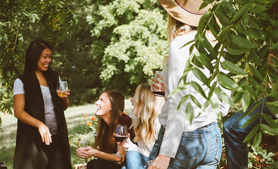 People enjoying a party in a garden with drinks.