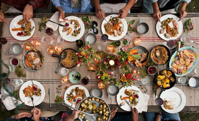 People sat around table full with BBQ food.