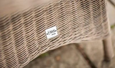 Close-up of woven outdoor furniture with an RHS tag.