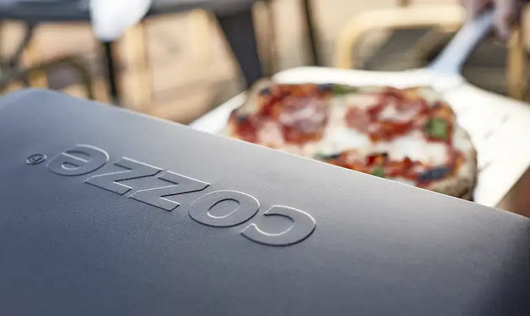Pizza being removed from a Cozze Pizza Oven