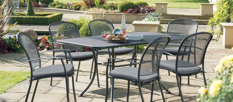 Caredo 6 Seater Dining Set with Slate Check seat pads from KETTLER's Classic range in a garden.