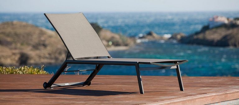 The Hydra Stacking Sun Lounger, from the Jati & Kebon range, on a wooden decking area.