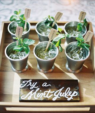 Summer cocktails with herb garnish on a rustic wooden tray.