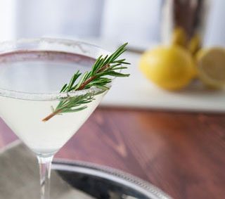 Gin martini with rosemary garnish.
