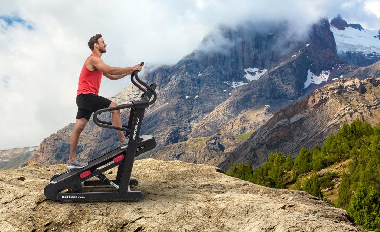 Man using high incline treadmill beside a mountain