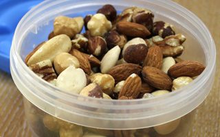 Detail of a nut mix in a plastic bowl.