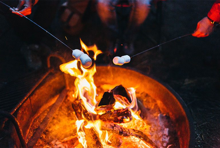 Flaming fire pit with two marshmallows.