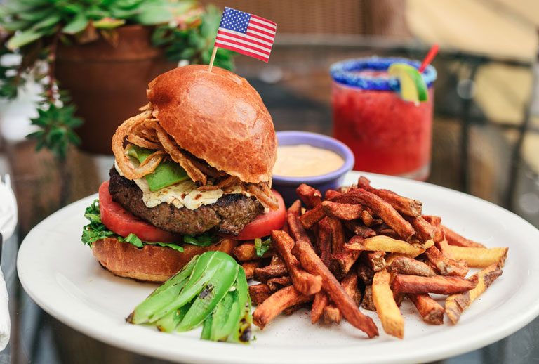 American style burger with side of sweet potato fries.
