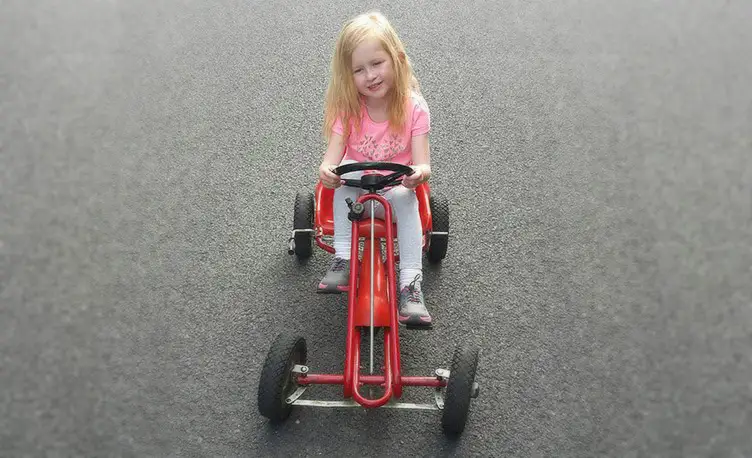 Girl playing on a 40 year old Kettler Go-Kart.