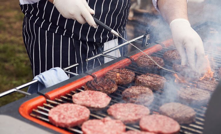 Burgers sizzling on an everdure by Heston Blumenthal barbecue.