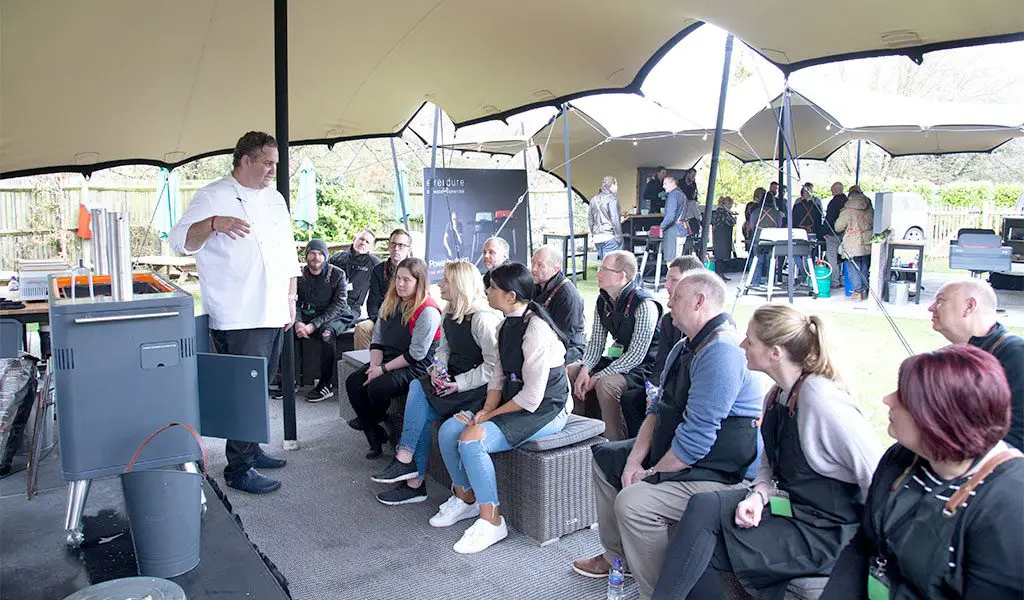 A Fat Duck chef teaching an audience how an Everdure by Heston Blumenthal HUB BBQ works.