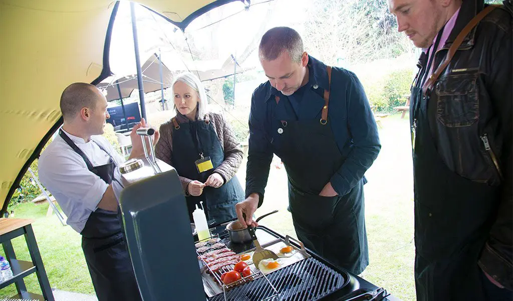 A Fat Duck chef teaching staff how to cook a full English breakfast on a Furnace gas BBQ.