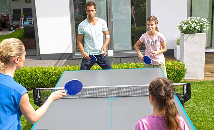 family playing table tennis outdoors