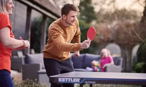 dad playing table tennis with kids outdoor