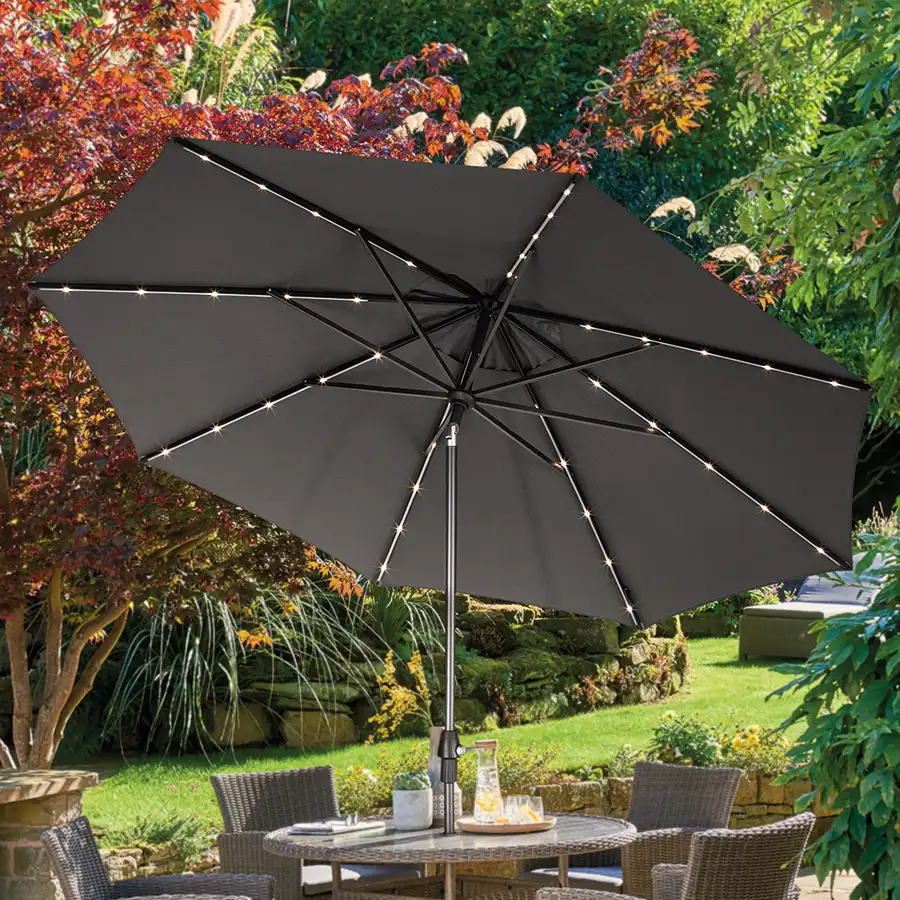 3m wind up parasol with led light tilted on patio dining set