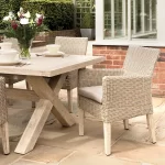 Detail image of Cora cross leg dining table in wood with cora wicker dining chair