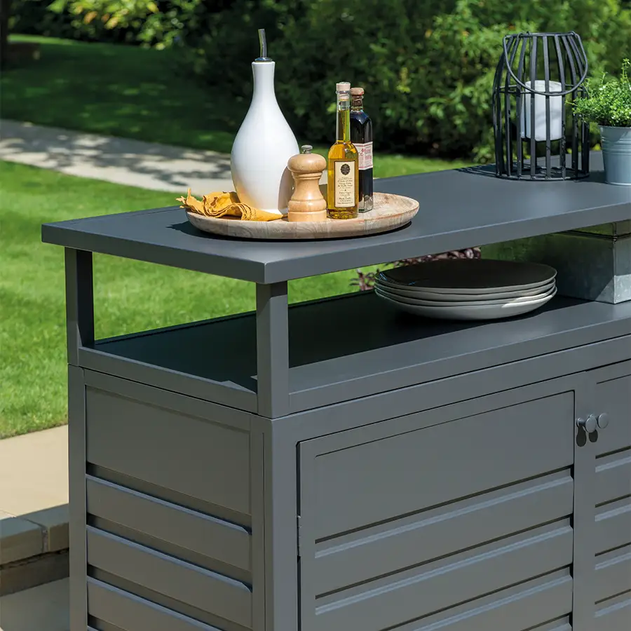 Aluminium sideboard with tray with oil on and lantern in garden set up
