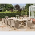 Cora dining set for 10 people with 280 x 110cm crossed leg wooden dining table and 10 wicker cora dining chairs on a on a garden terrace