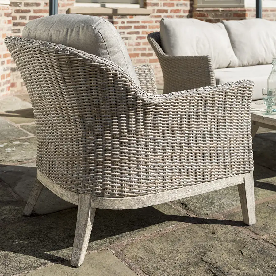 Detail image of side of cora wicker lounge armchair in the sunshine