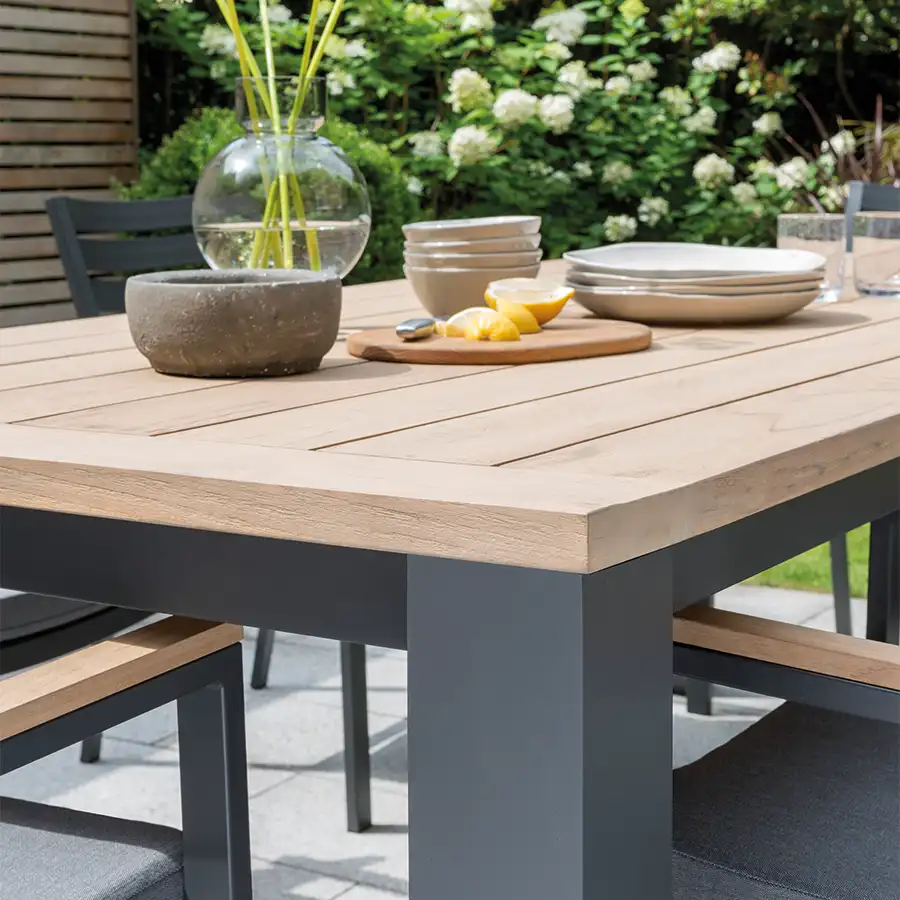 Close up of elba dining table in grey in a garden setting