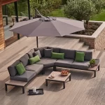 Free arm parasol set up over elba low lounge corner set on garden decking