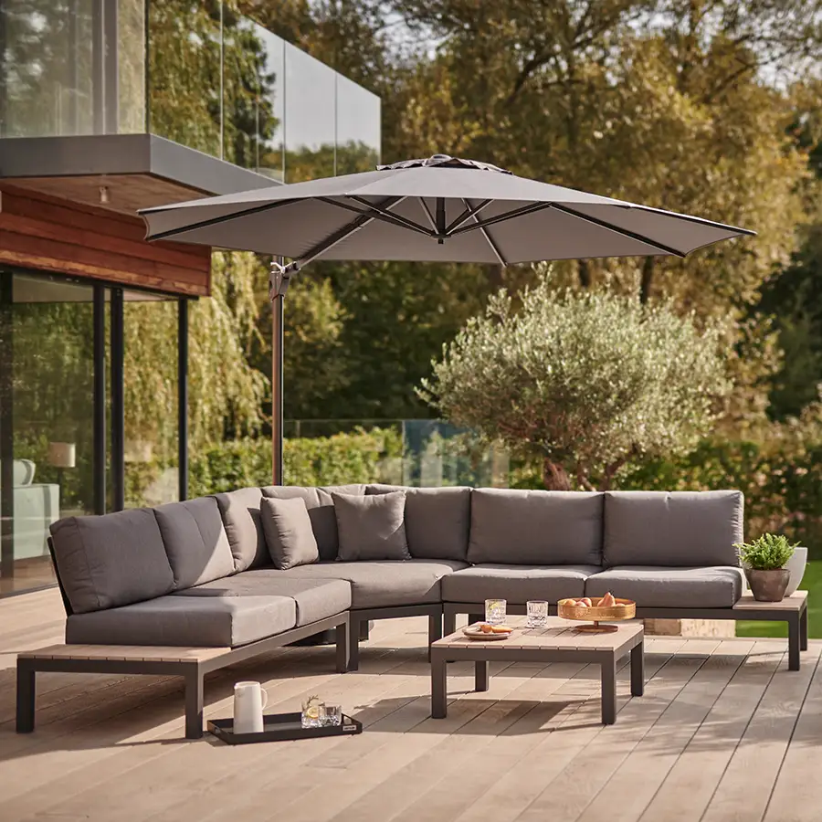 elba low lounge set with large corner sofa in grey under a free arm parasol on modern garden terrace