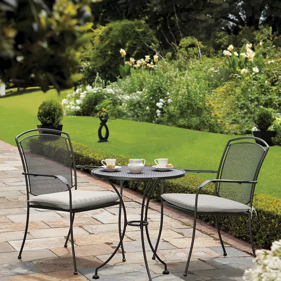 Pair of Henley armchairs with 70cm bistro table in iron grey with seat pads on a garden patio