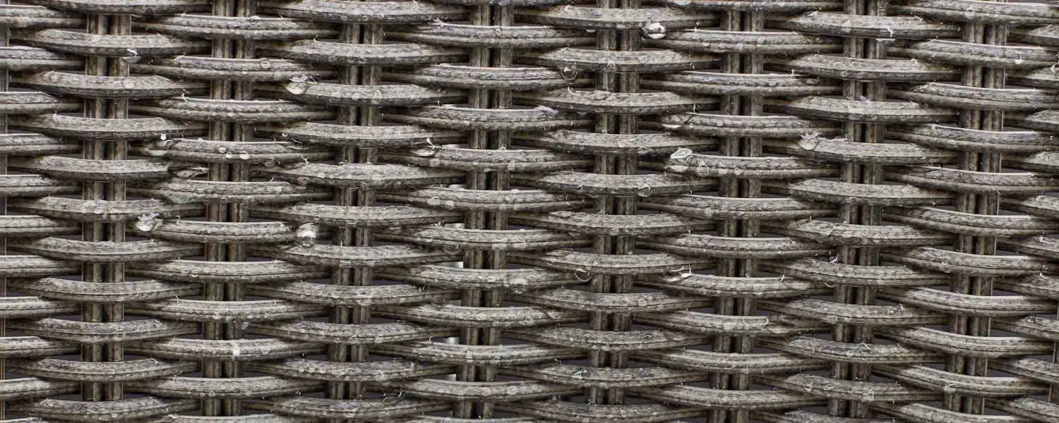 Close up of wicker material with water drops on it.