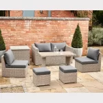 Palma compact corner set in white wash wicker with grey cushions on garden patio in the sunshine