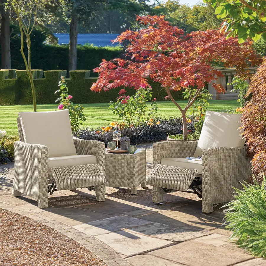 Palma Duo Relaxer set in oyster wicker with stone cushions with foot rest extended on garden terrace in the sunshine