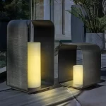 Palma LED Candle lights 35cm and 45cm in height each with warm light glowing on a dark evening in the garden