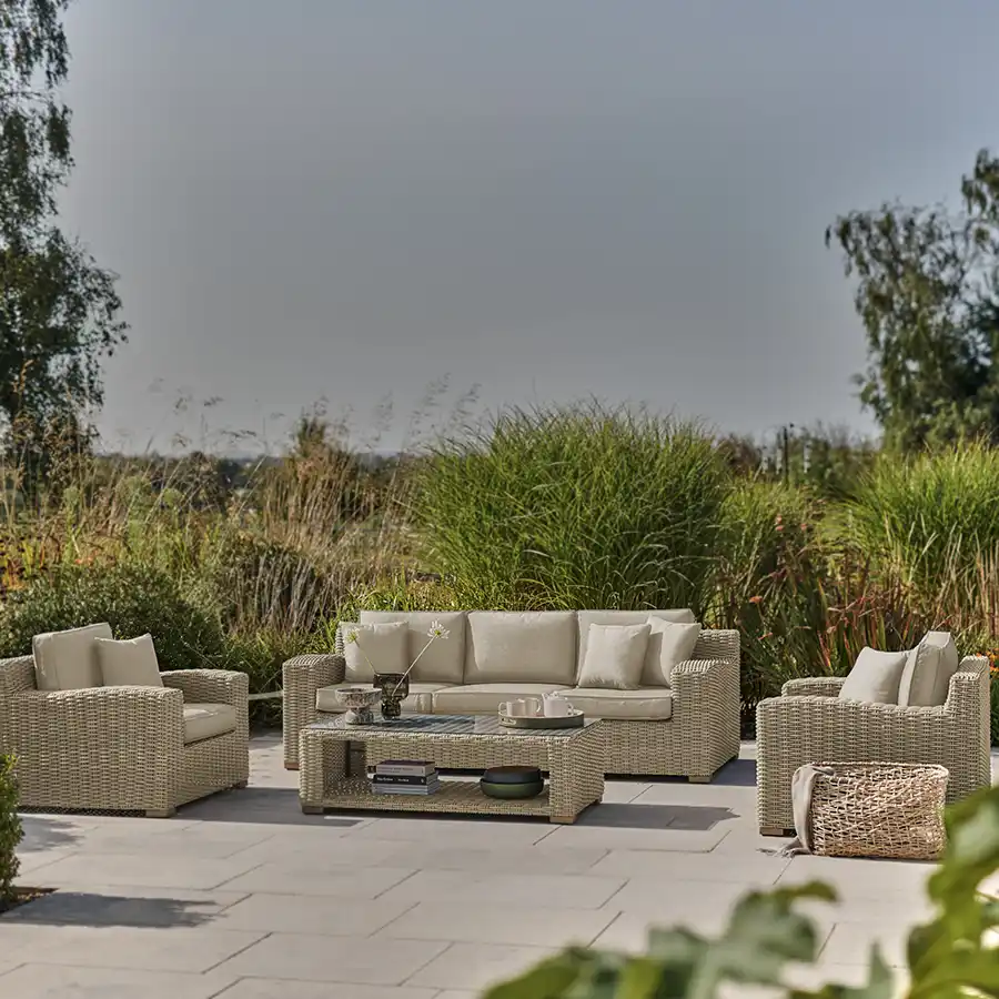 Palma luxe 3 seater sofa set in oyster wicker with stone cushions on a garden patio in the sunshine