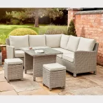 Palma mini fire pit table in oyster wicker a garden patio with brick wall behind