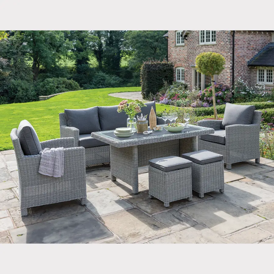 Palma Sofa Set in white wash wicker with grey cushions on a garden terrace with glass top table