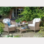 RHS Harlow Carr lounge set with 2 seat lounge set on a garden patio with flowers