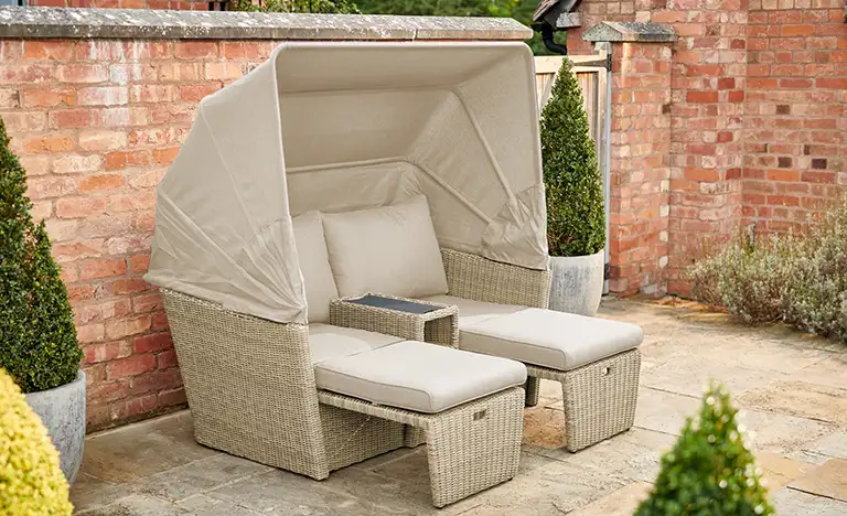 Palma day bed with sun shade up and chairs extended on a garden patio