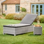 Palma sun lounger in white wash wicker with taupe coloured cushions on grass in the garden