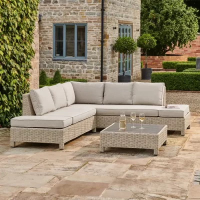 Palma low lounge corner set in oyster with stone cushions on a garden patio