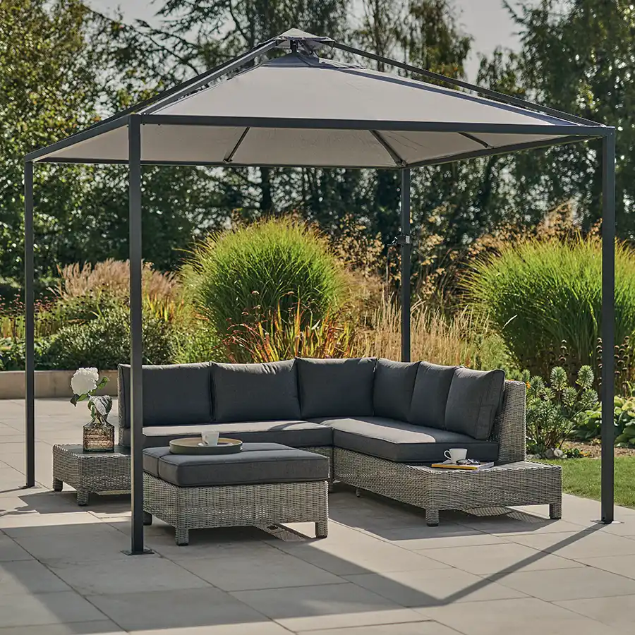 Palma low lounge corner set in white wash with taupe cushions on a garden patio underneath a panalsol pagoda.