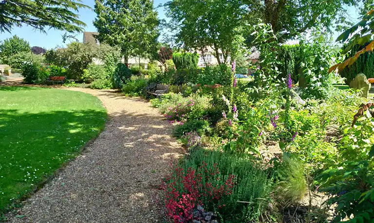 Graden with gravel path and border full of flowers
