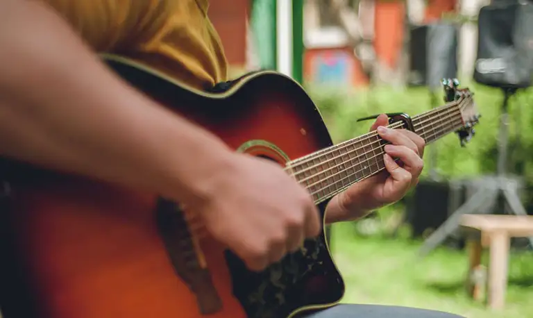 Boy playing the guitar in the garden