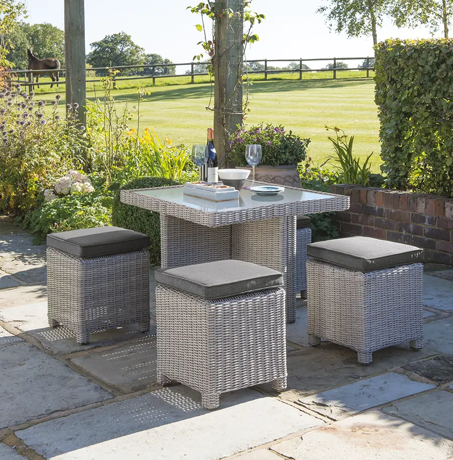 Palma Cube set with glass top table in white wash wicker with taupe cushions on a garden patio