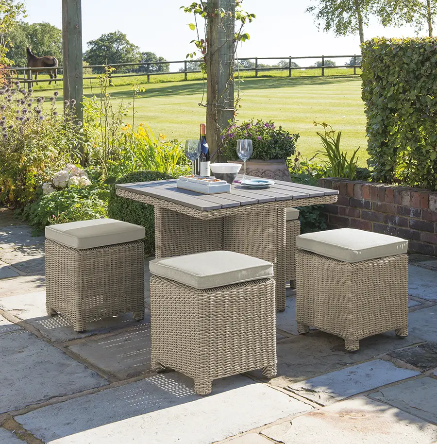 Palma Cube set with dark oal slat top table in oyster wicker with stone cushions on a garden patio