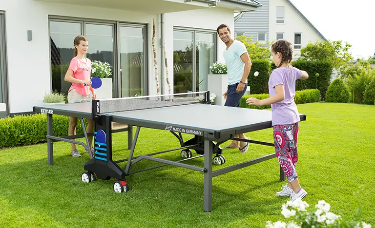Family playing table tennis in the garden