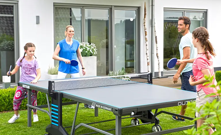 Family playing table tennis in the garden on a summers day