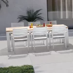 elba dining set with 6 dining chairs in white on a garden patio.