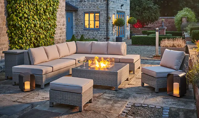 palma low lounge corner set in oyster with a firepit table alight.